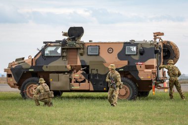 Avalon, Australia - February 27, 2015: Australian Army soldiers with a Bushmaster armoured Personnel carrier (APC). clipart
