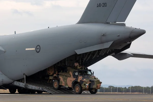 2015年2月27日 オーストラリア陸軍のブッシュマスター装甲兵員輸送機 Apc がオーストラリア空軍のボーイングC 17Aグローバルマスター輸送機から荷役 ロイヤリティフリーのストック写真