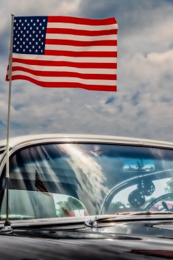 Virginia 'da 50' lerin klasik Amerikan arabası için Amerikan bayrağı dalgalandıran rüzgar..