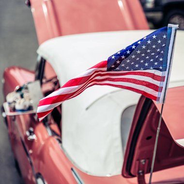 Virginia 'da 50' lerin klasik Amerikan arabası için Amerikan bayrağı dalgalandıran rüzgar..