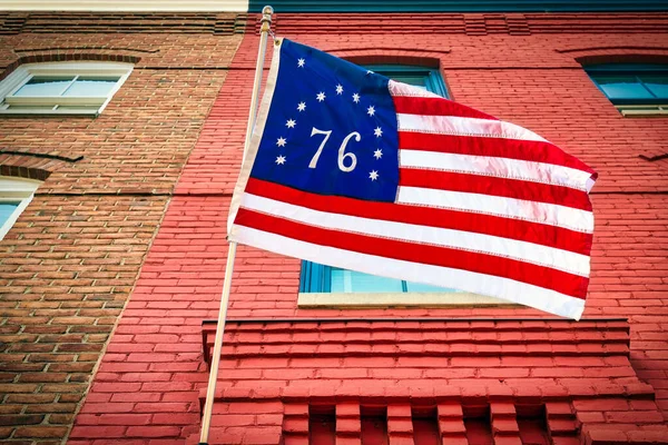 An American flag, the Bennington flag, hanging on a building in Alexandria, Virginia.