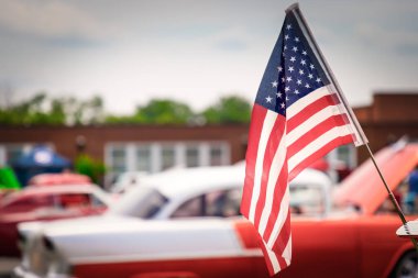 Virginia 'da 50' lerin klasik Amerikan arabası için Amerikan bayrağı dalgalandıran rüzgar..
