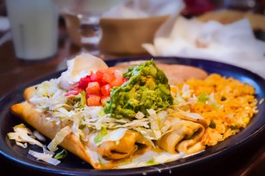 İki Chimichanga, domates ve guacamole ile, bir tabak pilav ve fasulye ile..