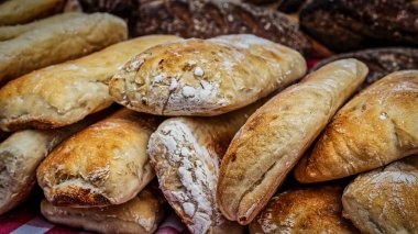 Açık hava pazarındaki masada duran bir yığın taze ekmek..