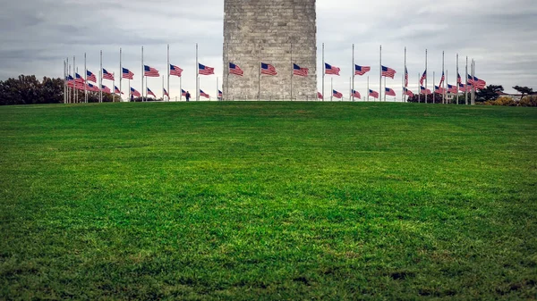 位于华盛顿特区华盛顿纪念碑底部的半桅杆旁的一圈美国国旗 — 图库照片