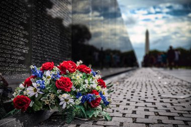 Washington, DC 'de Vietnam Gazileri Anıtı' na karşı oturan çiçekler..