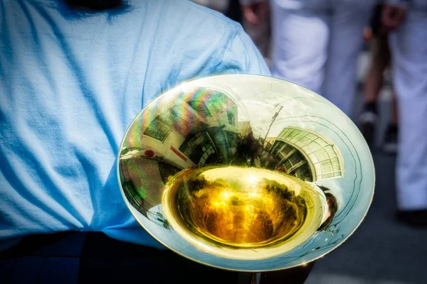 A musician carrying her French horn though the street following a parade in Shimoda, Japan.