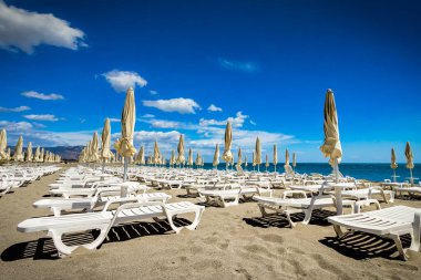 Güney İtalya 'da güneşli bir günde kumsalda başıboş plaj sandalyeleri.