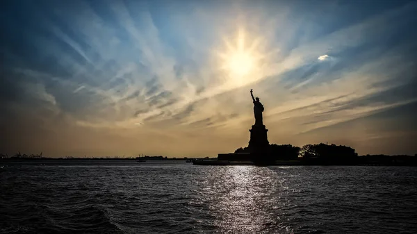 Σιλουέτα Του Αγάλματος Της Ελευθερίας Μπροστά Από Ένα Ηλιοβασίλεμα Που — Φωτογραφία Αρχείου