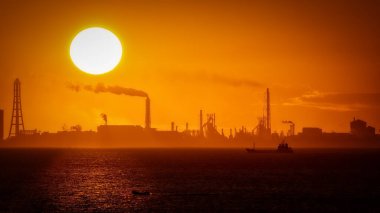 Japonya 'da gün doğumunda Tokyo Körfezi' nden bir gemi ve bir tekne geçiyor..