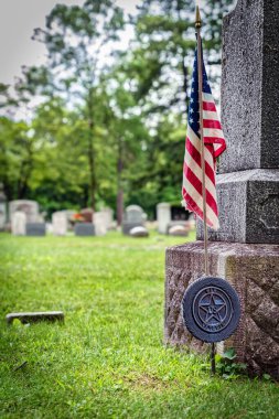 Wisconsin mezarlığındaki bir Amerikan gazisinin mezarında Amerikan bayrağı..