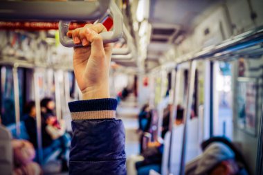 Bir el, Yokosuka, Japonya 'daki bir metro treninin sapına uzandı..