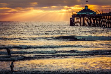Bir çocuk ve babası Imperial Beach, California 'da sörf yapıyorlar..