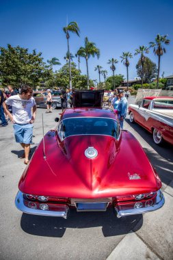 İzleyiciler 1966 model Corvette Sting Ray 'e bakıyorlar..