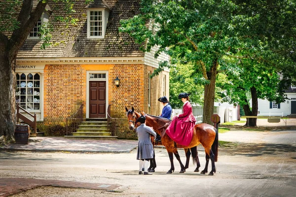 殖民地威廉斯堡市民们 穿着旧衣服 骑着马在街上集合 — 图库照片
