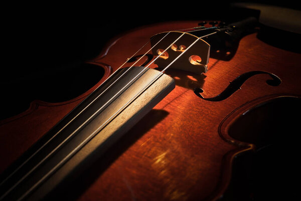 A violin sitting on a chair with soft lighting.