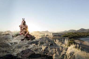 Orupembe, Kunene Region, Namibya. -13 Mayıs 2018: genç bir Himba kadın bir gün otlatma sonra onun sığır ev sürüleri. Himba hala Namibya Kunene bölgesinde geleneksel göçebe yaşam yaşıyor