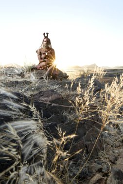 Orupembe, Kunene Region, Namibya. -13 Mayıs 2018: genç bir Himba kadın bir gün otlatma sonra onun sığır ev sürüleri. Himba hala Namibya Kunene bölgesinde geleneksel göçebe yaşam yaşıyor