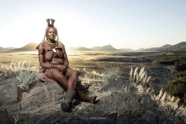 Orupembe, Kunene Region, Namibya. -13 Mayıs 2018: genç bir Himba kadın bir gün otlatma sonra onun sığır ev sürüleri. Himba hala Namibya Kunene bölgesinde geleneksel göçebe yaşam yaşıyor