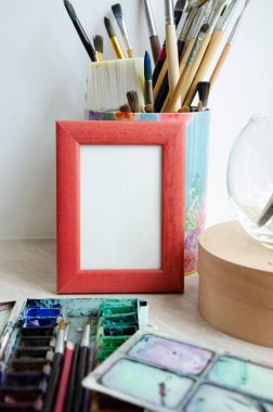 Sanatın, fotoğrafın, çizimin için çerçeve modeli, arka planda boya fırçaları olan çizimler. 