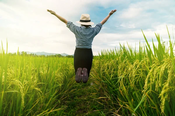 peasant woman jumps with joy as the rice product grows