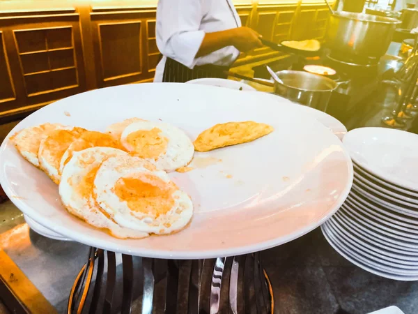 Aşçı lokantadaki müşteriler için omlet ve omlet pişiriyor..