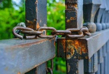 Eski ahşap bir çitte paslı demir zincir