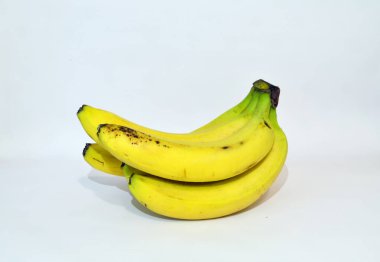 Beyaz arka planda siyah noktalı sarı ve olgun muzlar.