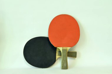 Beyaz arka planda kırmızı ve siyah tenis raketleri.