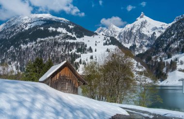 İsviçre 'nin Schwyz kantonundaki Wagital Vadisi' ndeki Wagital Gölü (Wagitalersee) etrafındaki kar kaplı ilk bahar manzaraları