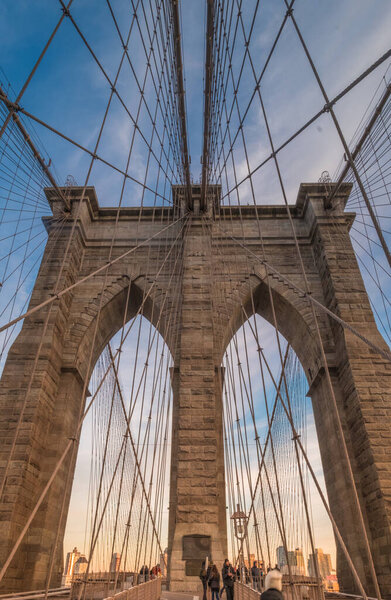 Detail of the Brooklyn Bridge neo-Gothic arches and steel suspension cables, civil engineering masterpiece, New York City