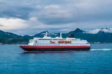 Gemi Svolvaer limanından, Lofoten Adaları 'ndan, Nordland, Norveç' te bir takımada ve geleneksel bir bölge olarak ayrılıyor. Kuzey Kutup Dairesi 'nin kuzeyinde. Lofoten doğal güzelliğiyle tanınır. Dramatik bir havası olan kendine özgü bir manzarası vardır.