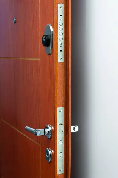 Open door of a family home. Close-up of the lock an armored door. White background.