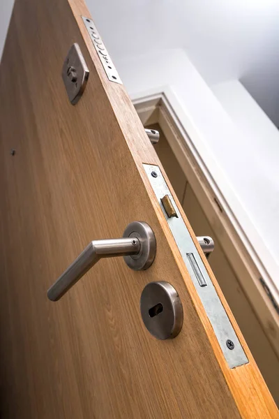 Güçlendirilmiş kapı. Düşük açı ve bir aile apartmanının güvenlik giriş kapısını kapat. Zırhlı ön kapı tahtadan kaplanmış. Ön plandaki çelik kol. Ev güvenliği.