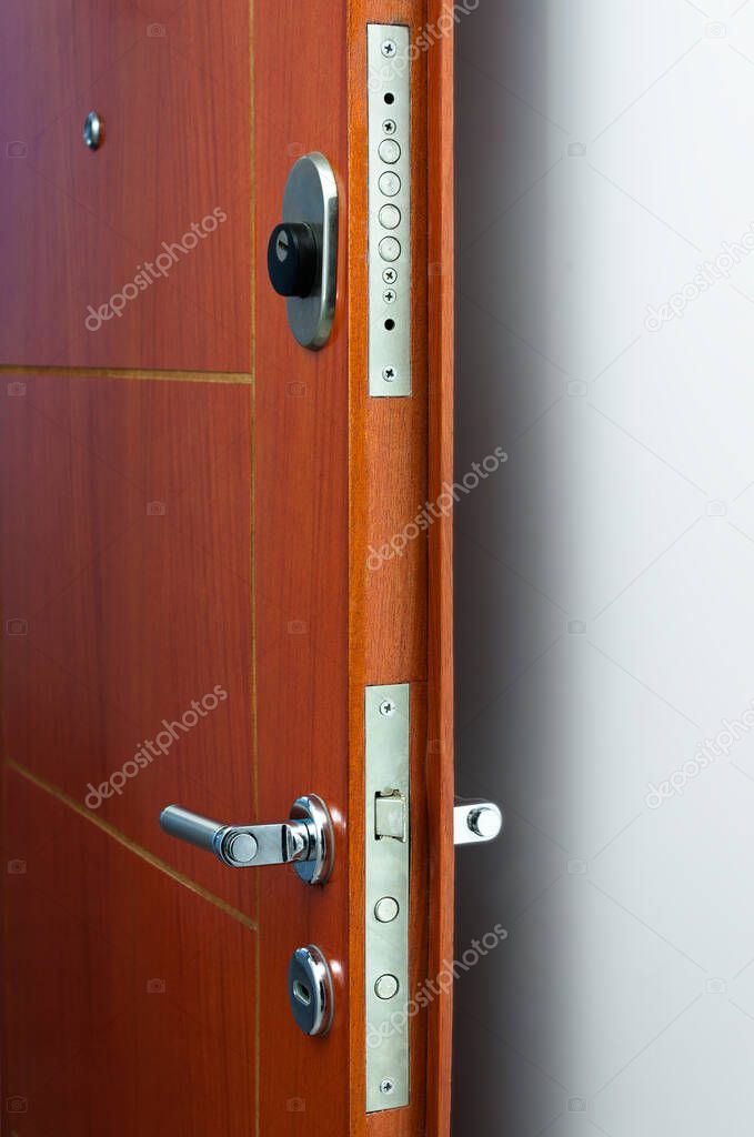 Open door of a family home. Close-up of the lock an armored door. White background.