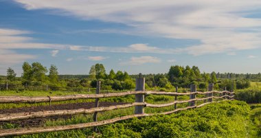 Sibirya köyünde eski bir ahşap çit var. Uzağa uzanıyor..