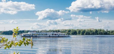 Kostroma, Rusya - 28 Haziran 2018: Güneşli bir yaz gününde yolcu gemisi Volga nehri boyunca hareket eder. Sahilden manzara. Pankart