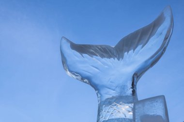 Mavi gökyüzü arka planına karşı bir balık kuyruğu heykeli. Boşluğu kopyala