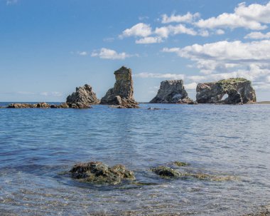 Taşlar ve kayalarla kaplı kıyı manzarası. Cape Velikan veya Ptichi, Sakhalin Adası, Rusya.