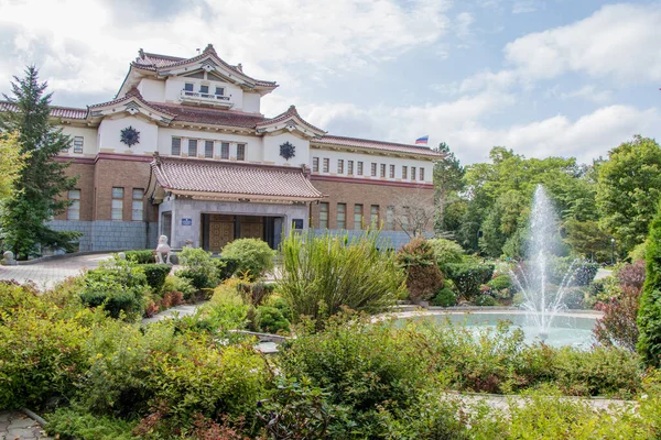 Yuzhno-Sakhalinsk, Rusya - 29 Ağustos 2019. Sakhalin Bölgesel Müzesi 1932 Japon binasında. Binanın etrafında fıskiyeli güzel bir park var.