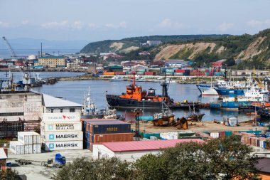 Korsakov, Russia - August 28, 2019. View of the commercial seaport on the shore of Aniva Bay. clipart