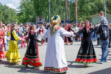 Yekaterinburg, Rusya, 15 Haziran 2019. İnsanlar el ele tutuşup daireler çizerek dans ediyorlar. Yıllık Tatarlar ve Bashkirs Sabantuy bayramı şehir parkında.