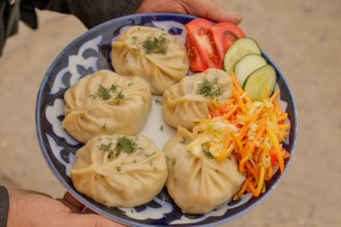 Geleneksel doğu manta yemeği ve tabağında sebze salatası..