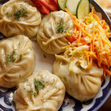 Geleneksel doğu manta yemeği ve tabağında sebze salatası..