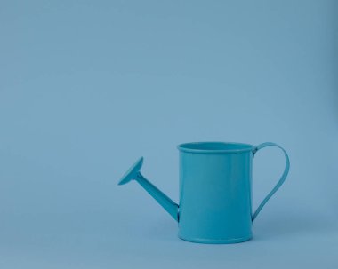 Mavi arka planda oyuncak mavisiyle sulanan teneke kutu. Mesaj için yer. Tarım kavramı.