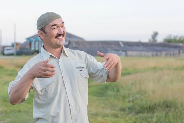 イスラム教徒の老人はシベリアの村の背景に立って笑顔 ロシア — ストック写真