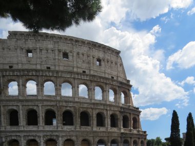 Roma 'daki Colosseum ya da Flavian Amfitiyatrosunun mavi bulutlu gökyüzüne karşı dış duvarının detaylı görüntüsü
