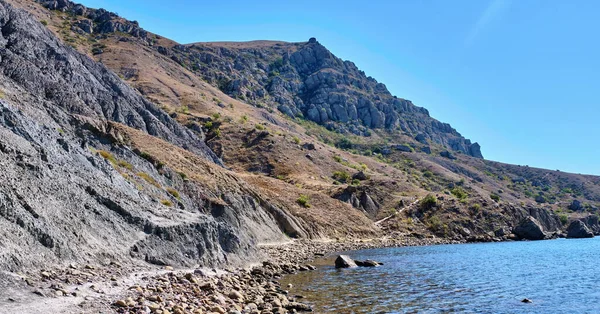 Turistler Karadeniz kıyısındaki Cape Meganom 'un kayalık kıyıları boyunca yürüyorlar..