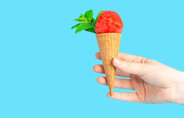 Una mano de mujer sosteniendo un cono de helado con sandía y menta — Foto de Stock
