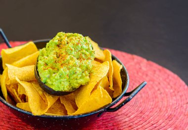 Siyah metal kasede avokado ve guacamole.